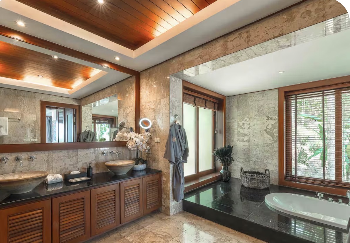Marble en-suite bathroom with twin stone basins and a soaking tub